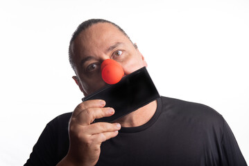 Adult man with clown nose posing, selective focus, white background.