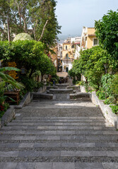 Obraz premium Taormina, Italy - June 19, 2024: Stairs leading down to the town.