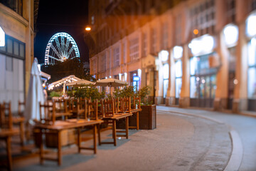 Obraz premium Budapest, Hungary - August 10, 2024: View to the ferris wheel from Anker koz street at night. Focus tilted to the ferris wheel.