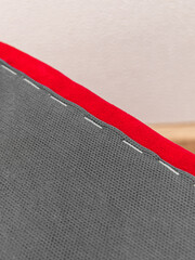 The lower part of furniture. Fabric upholstery with furniture staples. Vertical