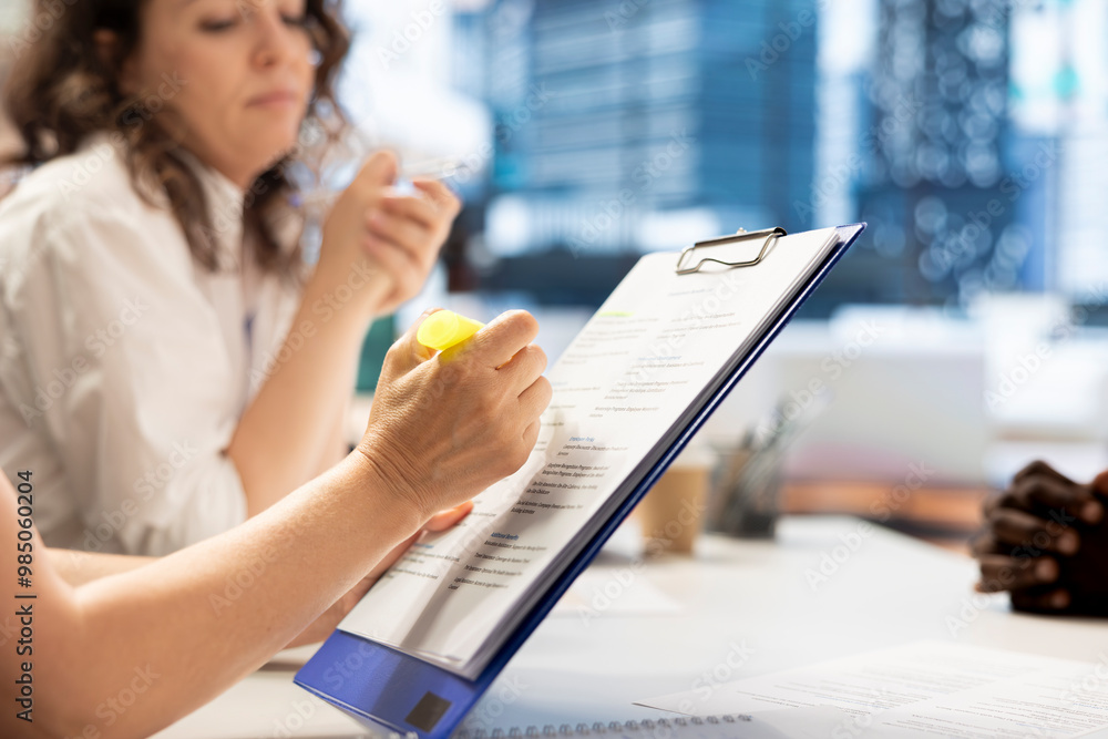 Poster hr employee using highlighter marker on paperwork, ensuring candidate possesses skills needed to ful