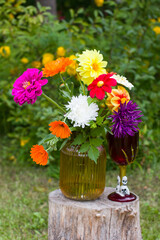 autumn still life vase with cynias, a mug in the form of a pumpkin. A glass with a skull, Halloween party