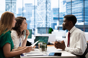 Stock market company HR professional reviewing candidate CV, asking questions about qualifications. Person getting hired by recruiter after proving skills for economic startup job