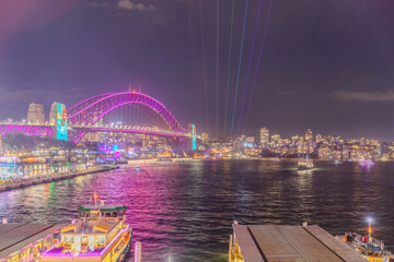 Obraz premium Colourful Light show at night on Sydney Harbour NSW Australia. The bridge illuminated with lasers and neon coloured lights for the Sydney Vivid light show