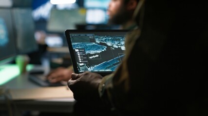 Army telecommunication systems operator using satellite software on tablet, providing combat...