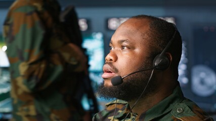 Military dispatcher relays info from army intelligence analysts to troops on front lines, close up...