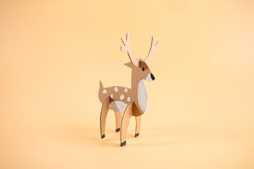 paper craft model of a deer on a plain background, recycling concept, fun project for anyone interested in crafts or animal models.