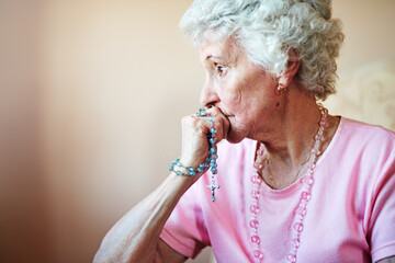 Old woman, Christian and rosary beads in home, spiritual worship and catholic meditation. Female...