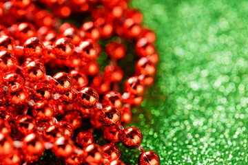 Red Beads on Sparkling Green Background for Cheerful Christmas Decoration Concept, Copy Space