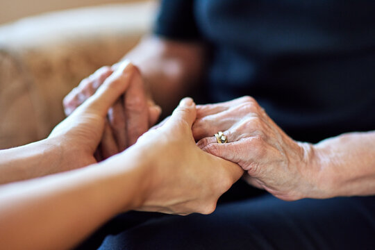 Senior, hope or people holding hands for praying, support or comfort for care, trust or worship. Closeup, faith or mourning with widow or kindness for help, grief or peace for loss or healing in home
