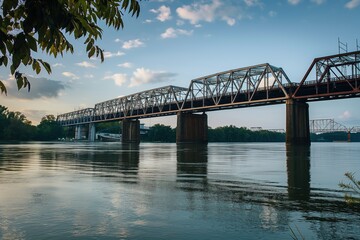 Fototapeta premium Decatur Alabama cityscape with Steamboat Bill Bridge over Tennessee River. Beautiful blue sky, architectural structure, historic landmark. River view, travel, tourism, cityscape, architecture,