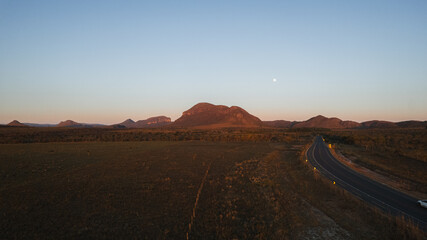 aerial view of highway with Morro da Baleia and fields, at sunset, Chapada dos Veadeiros, Goiás, Brazil