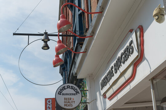 exterior building facade and sign of Riverside Burgers, a hamburger restaurant, located at 688 Queen St E in Toronto, Canada
