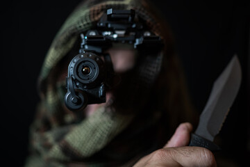  Special force soldier in camo, with a night vision device and a sharp knife in his hand in the darkness.