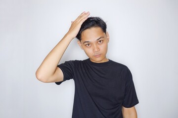 portrait of a handsome Indonesian man posing randomly wearing a black shirt on a white background isolated