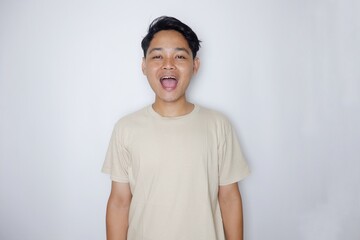 portrait of a handsome Indonesian man posing randomly wearing a Cream shirt on a white background isolated