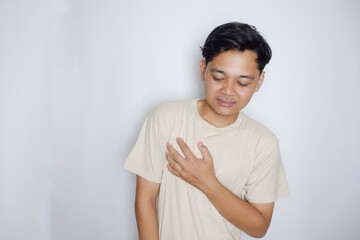 Obraz premium portrait of a handsome Indonesian man posing randomly wearing a Cream shirt on a white background isolated