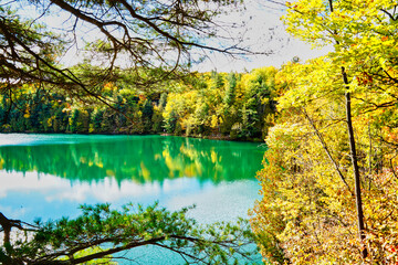 The azure-green waters of Pink Lake is offset against the deep yellow colours of the boreal forests...
