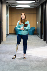 At office, Standing in hallway, woman with prosthetic leg holding tablet, smiling confidently
