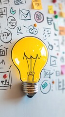 A bright yellow light bulb against a wall covered with doodles and sticky notes.