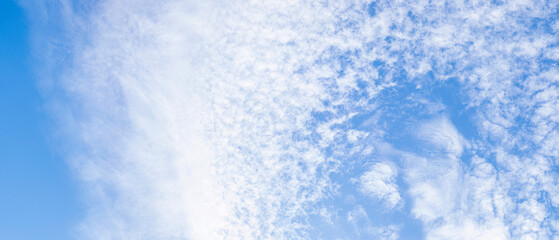 The bright blue sky with white clouds in the sunny day.