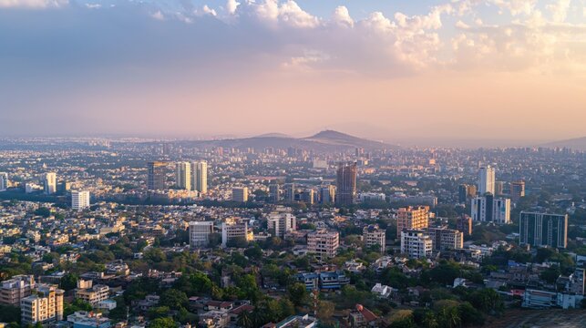 Pune cityscape in Maharashtra, India. Aerial shot of metropolis with modern skyscrapers and urban landscape. Hazy sky with smog and foggy atmosphere. City buildings and structures in the foreground.