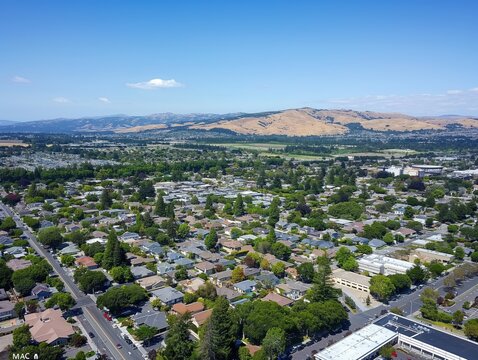 Aerial shot of city of Pleasanton, California, USA. Modern urban landscape with park, buildings, streets, and tower. Cityscape with beautiful architecture and outdoor spaces.