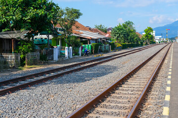 Obraz premium railway in the countryside, railroad tracks in the countryside, railway in Indonesia, train and railway, railway in the mountains, railway tracks, railway in the village, travel by train in Indonesia