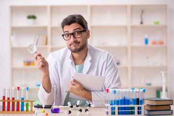 Young male chemist sitting at the lab