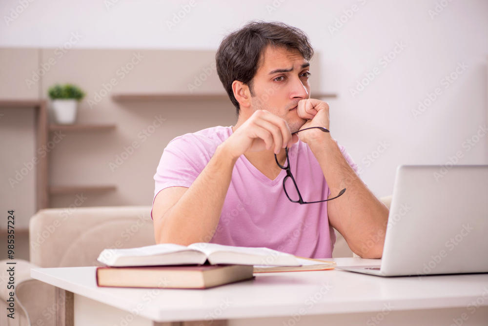 Canvas Prints Young male student preparing for exams at home