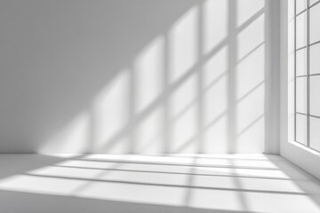 Obraz premium Minimalist white room with window and sunlight casting shadows on the floor.