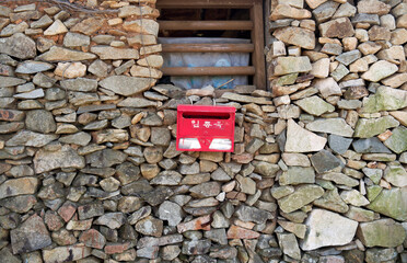 Cheongsan-myeon, Cheongsando Island, Wando-gun, Jeollanam-do, South Korea - October 15, 2013: Mailbox hanging outside the stone wall of a house