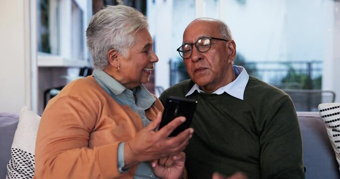 Elderly couple, phone and smile on sofa with media, photo memories and new memory aid app. Senior people, mobile and happy in home for innovative software, travel planning and choosing accommodation