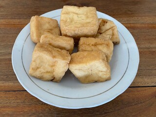Fried tofu on a plate and wooden table