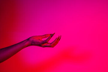 A terrifying witch's hand with long red nails, resembling a demon or vampire. Its gnarled...