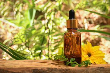 aromatherapy bottle with oil for homeopathic medicine or herbal medicine. Massage Oils. Natural cosmetics, skin care product in brown glass bottle on wood. Bottle with floral essential oil, close up 