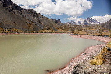 Laguna de color verde con arenas rojizas cerca del nevado de Ausangate en la Cordillera de...
