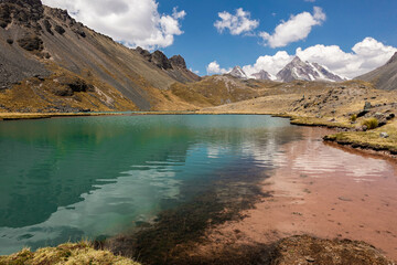 Laguna de color turquesa con arenas rojizas cerca del nevado de Ausangate en la Cordillera de...