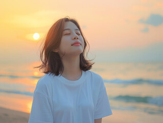 Obraz premium Smiling Asian woman on the beach, relaxing.