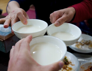 Hands toasting with Korean food Makgeolli(raw rice wine) at a resturant, South Korea 