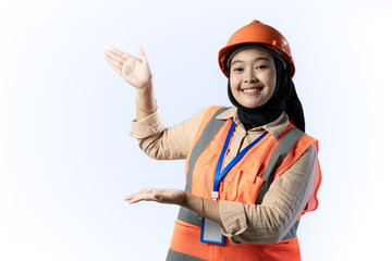 Young Asian female construction worker in hijab smiling confidently while showing her side with her hand, industrial and construction advertising concept, isolated on white background.