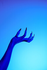 A blue witch hand with sharp red nails, set against a backdrop of blue fire. This eerie figure embodies demonic, ghostly, and zombie elements, perfect for Halloween horror and fantasy settings.