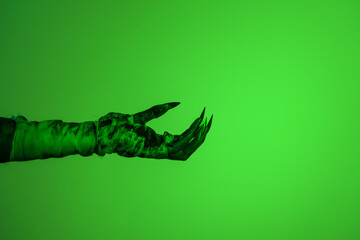 A bloodied witch hand wrapped in bandages, set against a green fire background. This demonic hand blends elements of vampires,aliens, and ghosts, evoking a spooky, monstrous feel perfect Halloween