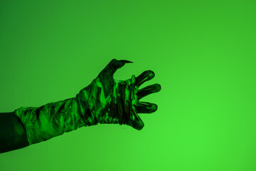 A bloodied witch hand wrapped in bandages, set against a green fire background. This demonic hand blends elements of vampires,aliens, and ghosts, evoking a spooky, monstrous feel perfect Halloween