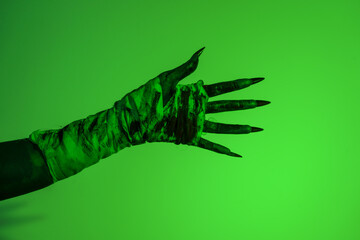 A bloodied witch hand wrapped in bandages, set against a green fire background. This demonic hand blends elements of vampires,aliens, and ghosts, evoking a spooky, monstrous feel perfect Halloween