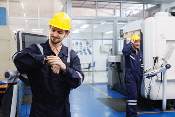 Industrial engineer worker looking at smartwatch time check of working hours. Industry factory working hours afternoon break times for lunch.