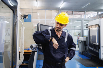 Industrial engineer worker looking at smartwatch time check of working hours. Industry factory working hours afternoon break times for lunch.