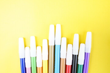 Colorful Markers on Yellow Background