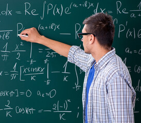 Young male student studying math at school