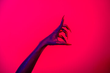 A witch hand with long nails appears against a red fire background, evoking a demonic, monstrous presence. Blending vampire, alien, ghost, and zombie elements, it perfectly embodies Halloween